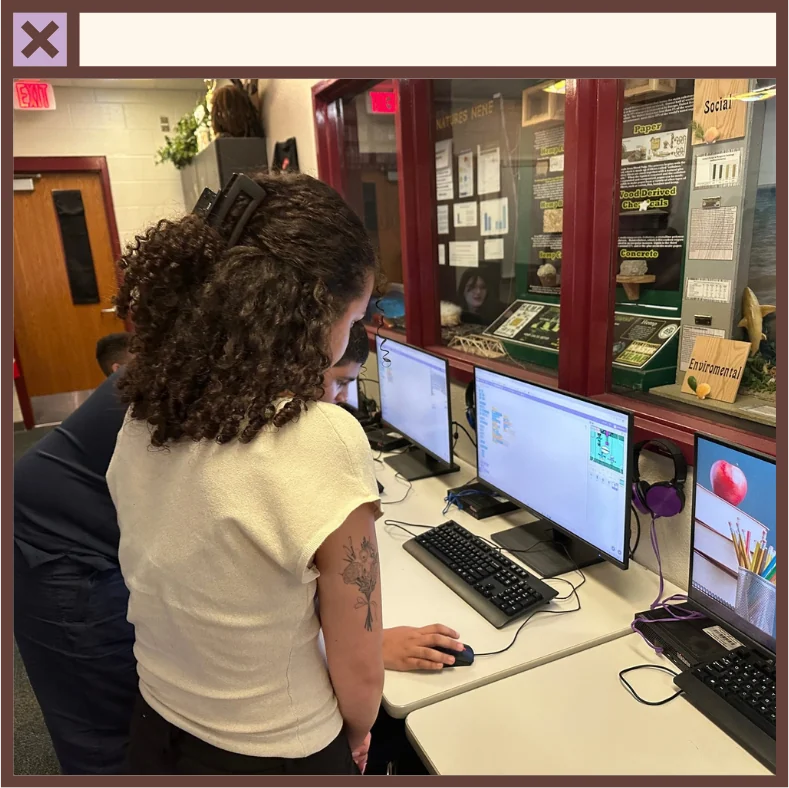 Helping a student build a Scratch coding project in a school computer lab
